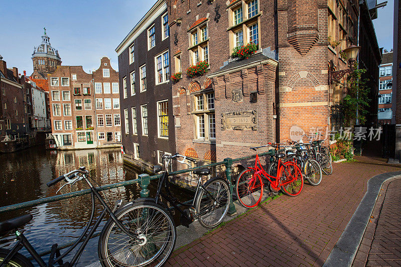 阿姆斯特丹的城市景象与许多自行车在典型的水渠和桥在阳光明媚的早晨