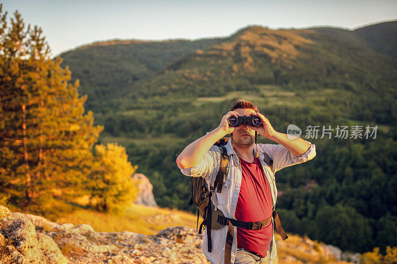 一个人用双筒望远镜看