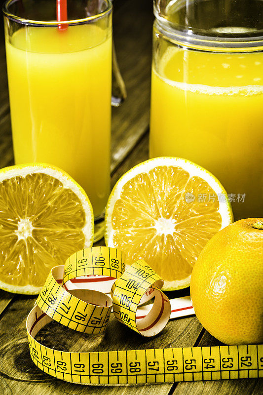 橘子汁和切片用卷尺放在木桌上