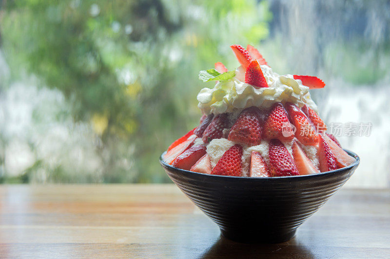 近距离的冰草莓Manue碗上的桌子