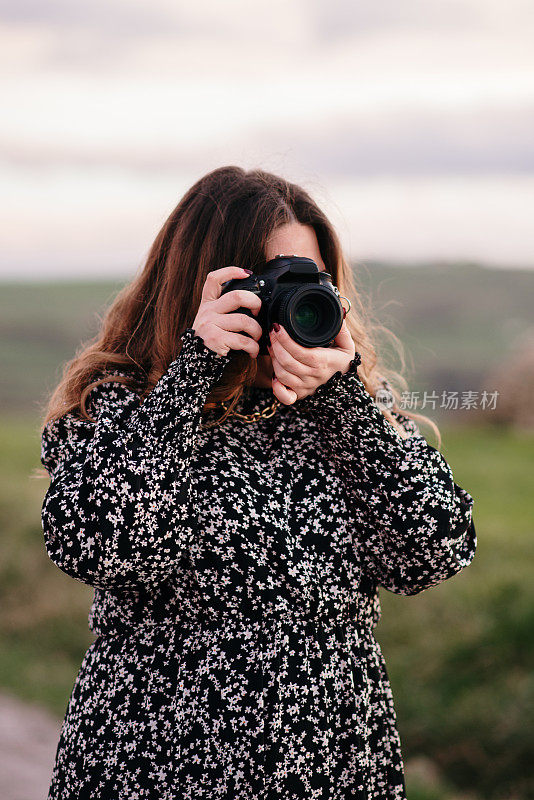 年轻女子用单反相机拍照