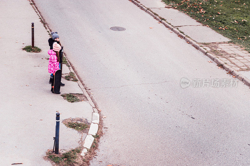 俯视图的女孩过马路与滑板在他们的手
