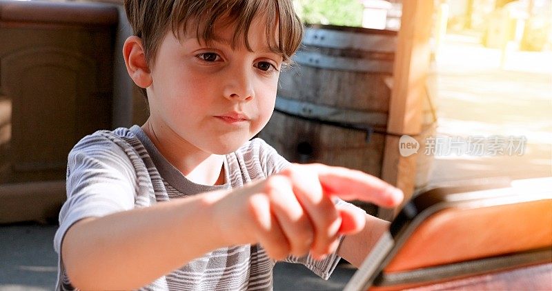 小男孩在远程学习时用他的电子平板电脑与老师和同学互动