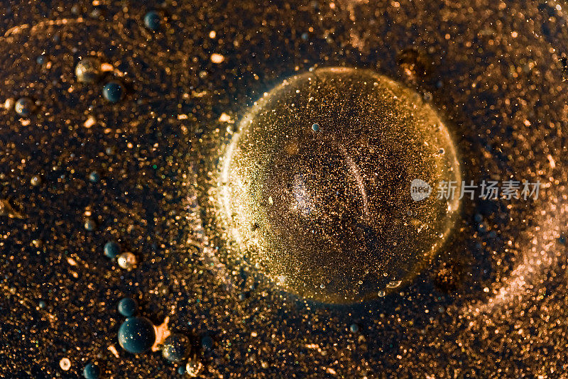 也许你能在这张照片中看到，一个金色的气泡，背景是金色的粒子。
