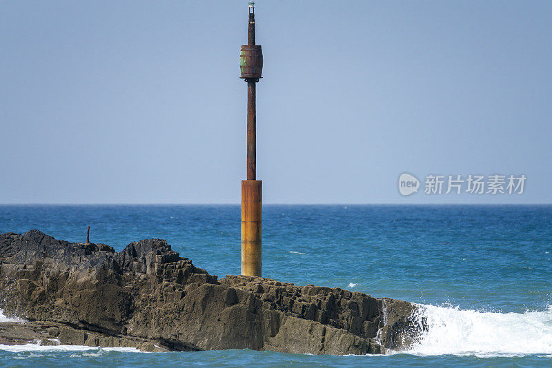 在康沃尔的布德海滩，有警告信号的岩石露头。