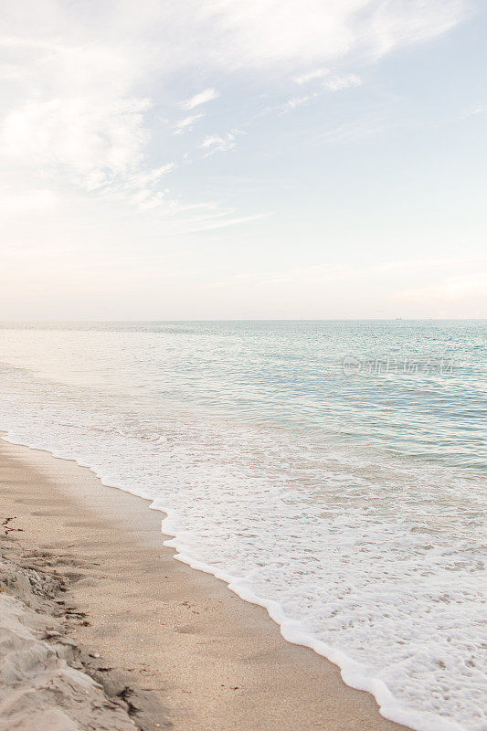 2021年8月，新冠病毒三角洲变种抬头期间，佛罗里达高地海滩日落时，蓝绿色海浪席卷空海滩海岸线
