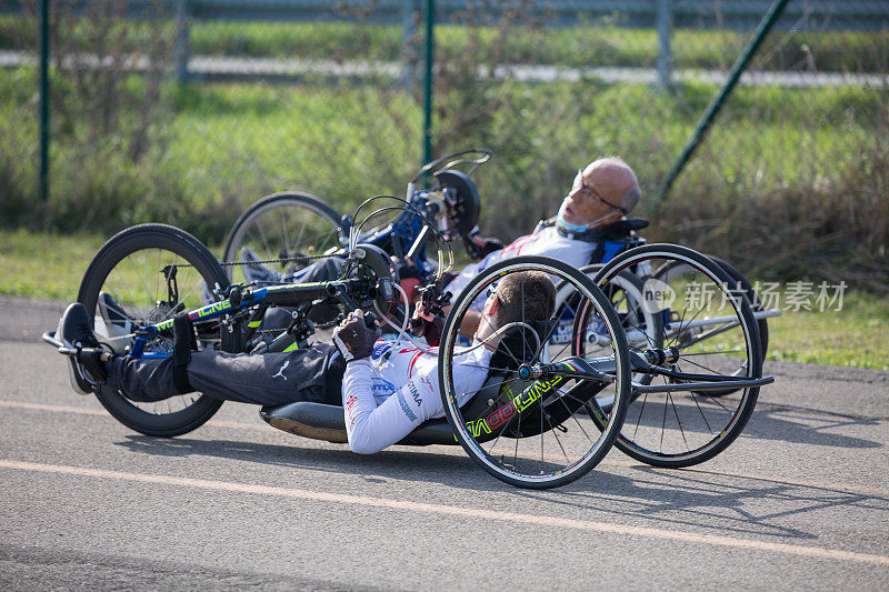 一对残疾运动员在赛道上手持自行车训练