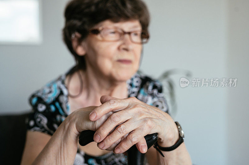 老年妇女在家里拄拐杖的肖像