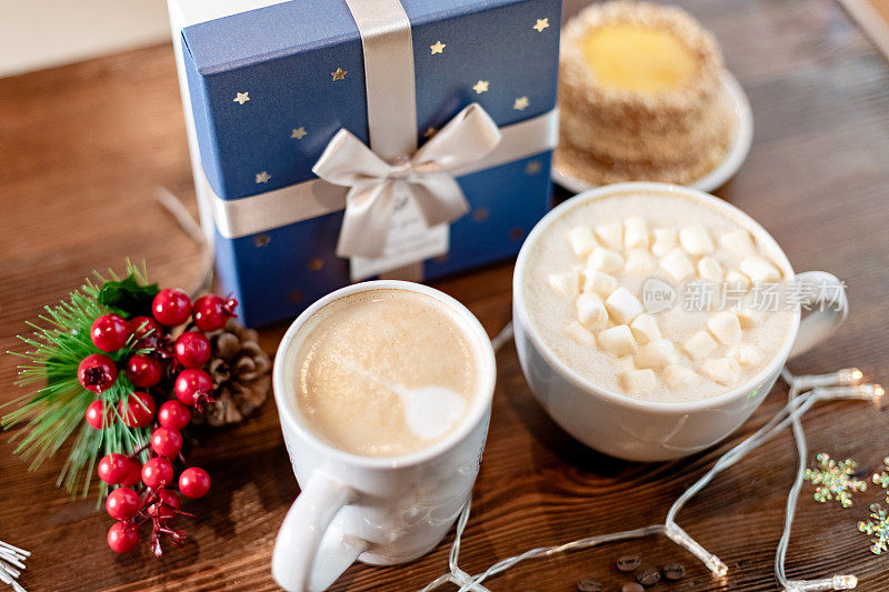 圣诞咖啡，木桌上有花环和灯。与新年礼品盒合影。甜点，蛋糕和丝带礼物。庆祝的心情。圣诞快乐，万事如意
