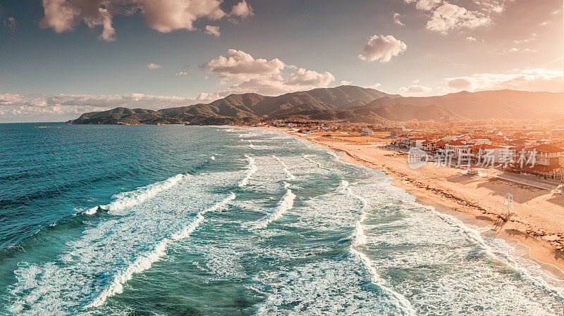 引人注目的全景鸟瞰图，标志性的萨蒂度假小镇和著名的漫长而空旷的沙滩在日落时分与巨浪。在希腊哈尔基迪基度假