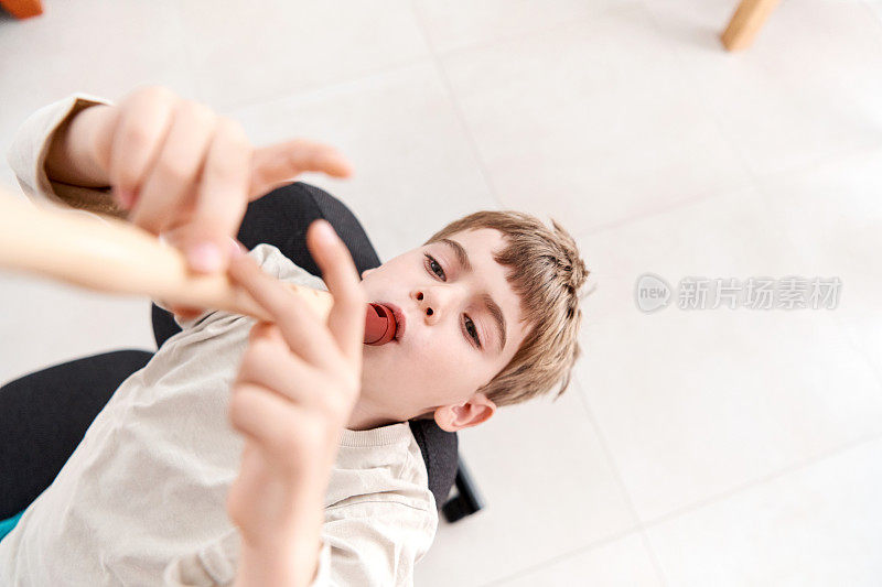 在因冠状病毒爆发而被封锁期间，一个孩子在家里练习长笛