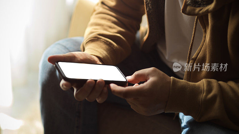 一名男子在智能手机上发短信，手机白屏样机。