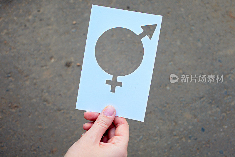 象征性别平等的沥青背景，在女性手中。