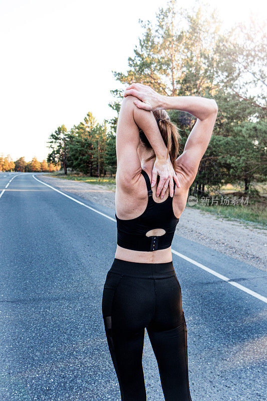 一名白癜风患者在慢跑前热身。
健康女性跑步前热身，伸展手臂放松。跑步的人健身的背景。