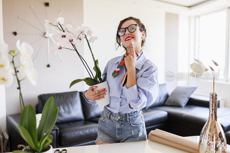 家庭主妇照料着家里的花草，五颜六色的蝴蝶兰。照顾家庭植物的女人。捧着白花的园丁