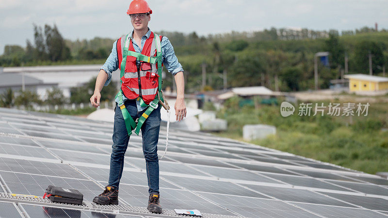 男性工业工程师和穿着安全制服的女性技术人员在屋顶工厂工作，检查维护和维修太阳能电池板。可再生能源工业。太阳能发电。