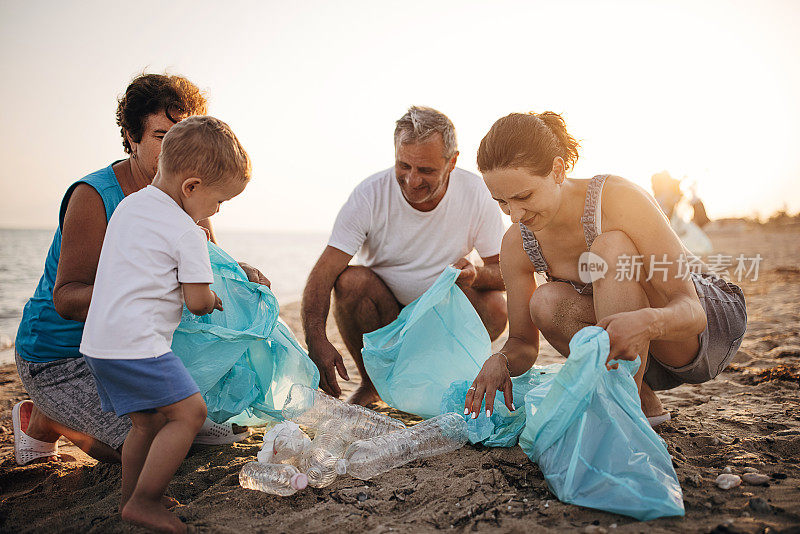 多代同堂——母亲，儿子，祖父和祖母，在海滩上捡垃圾