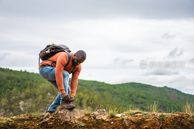 非洲裔男子在自然公园系鞋带