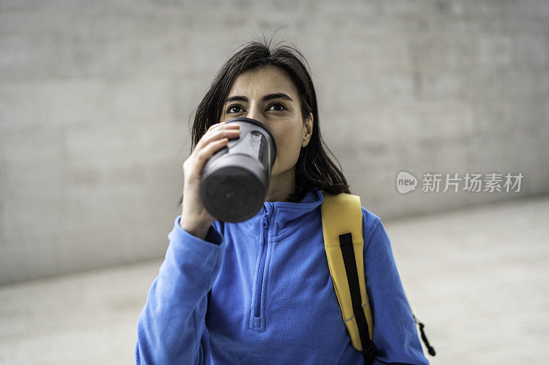 年轻女子在户外运动后喝水