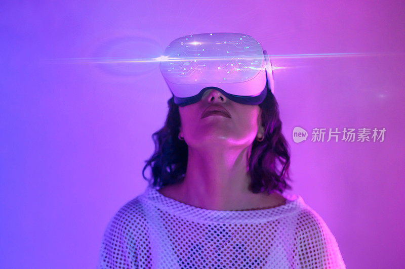 在紫色和粉红色的空间里，女子戴着VR头盔