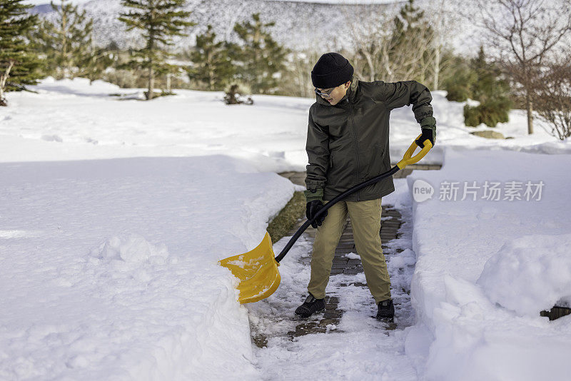 男孩在家里铲雪