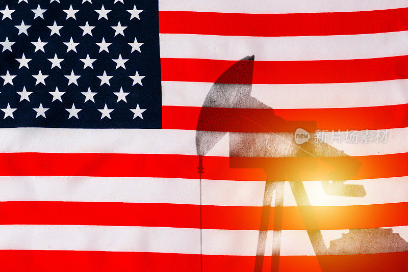 美国国旗背景上的石油钻井泵剪影。油泵背景为美国国旗。双重曝光。