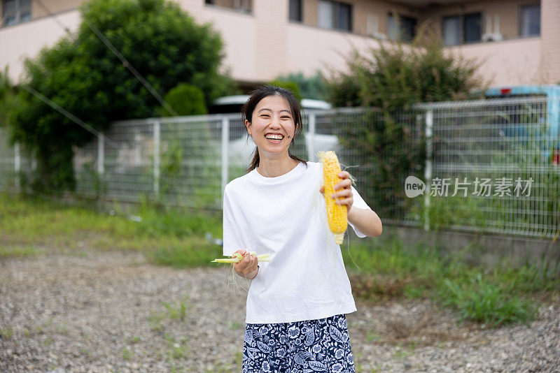 快乐的女人拿着玉米