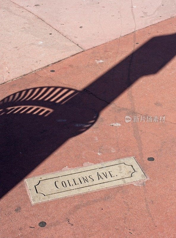 柯林斯大道，在街角贴着招牌和垃圾桶的影子