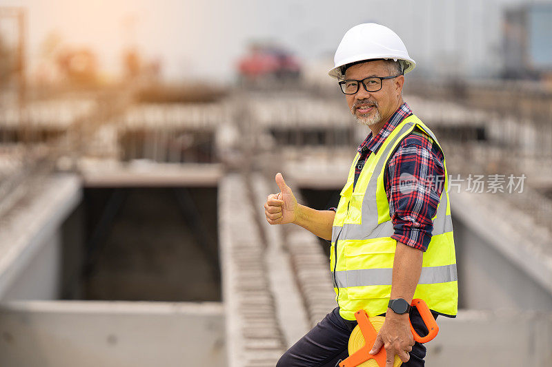 男工程师在道路施工过程中检验和测量标准混凝土梁。在建筑工地