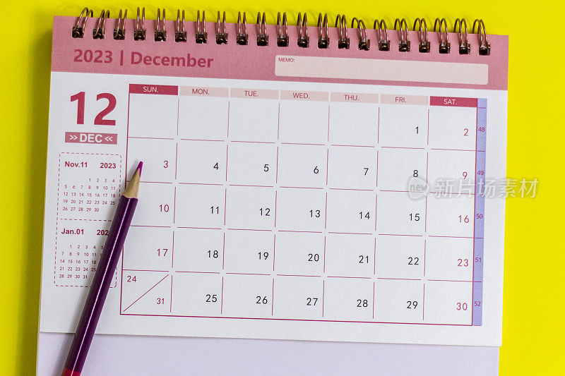 木制桌子的背景是2023年12月日历。为每一天做计划。