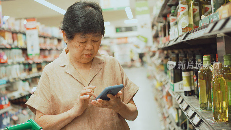 亚洲老年妇女比较食品价格、在超市购物、高生活成本、通货膨胀和健康积极的老年生活方式概念