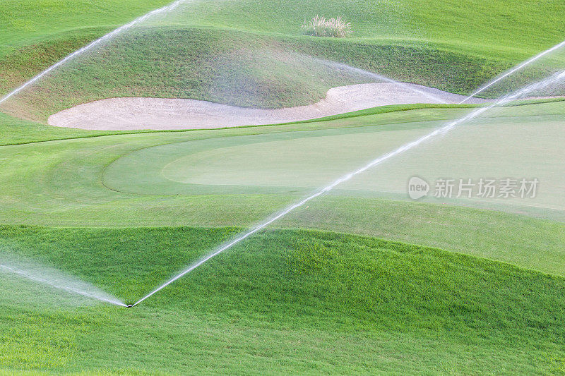 绿色高尔夫球场的洒水系统正在工作。