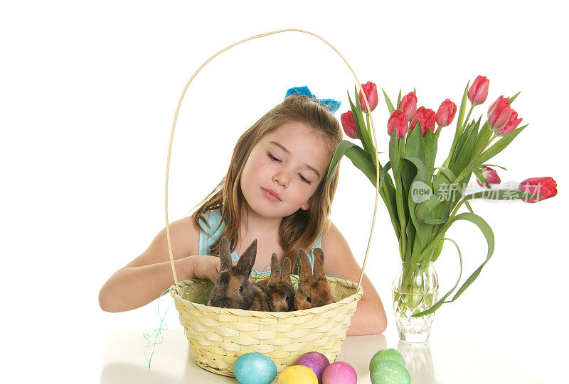 小女孩在复活节篮子里抚摸兔子