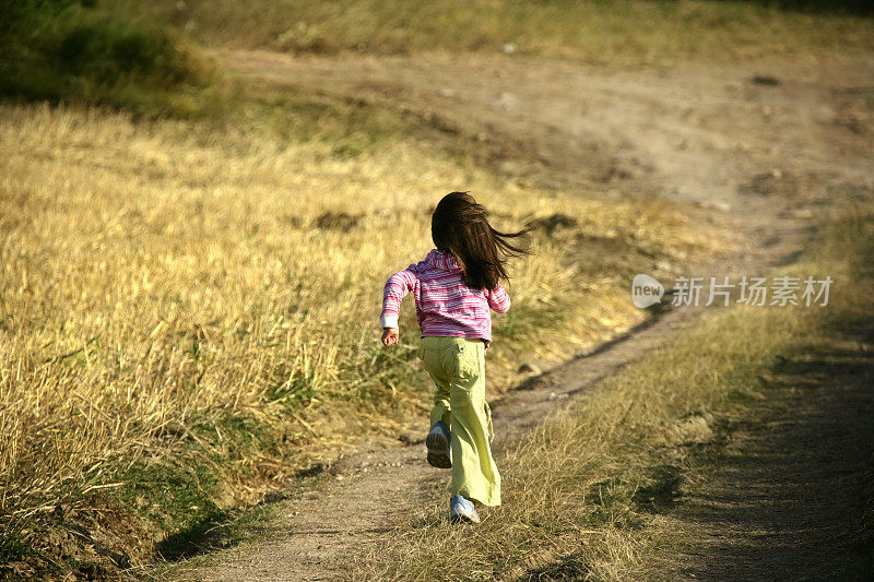 小女孩在土路上奔跑