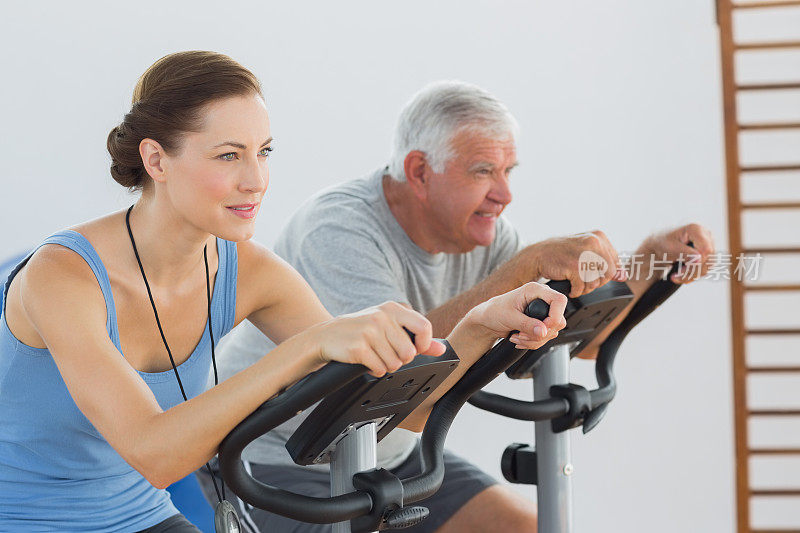 教练和老年人在健身自行车上锻炼