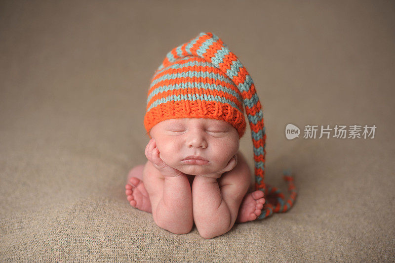 新生儿睡在一个彩色针织帽