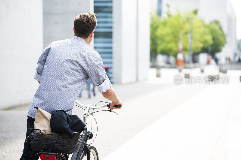 在大城市(柏林)的街道上骑自行车的人的背后