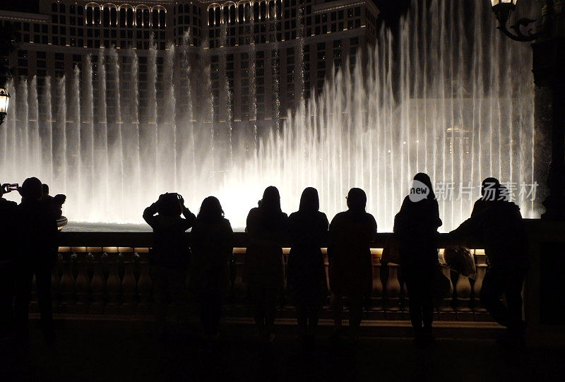 晚上喷泉旁有几个人的剪影。