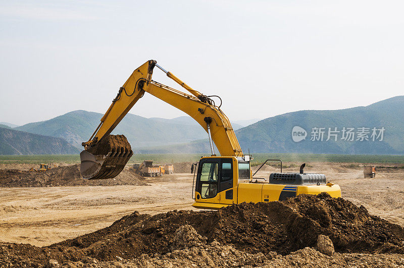 挖掘机将土装进自卸卡车，土方工程。