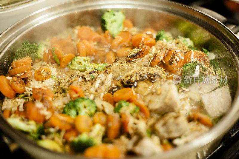 锅内盛满鸡肉，蔬菜汤。