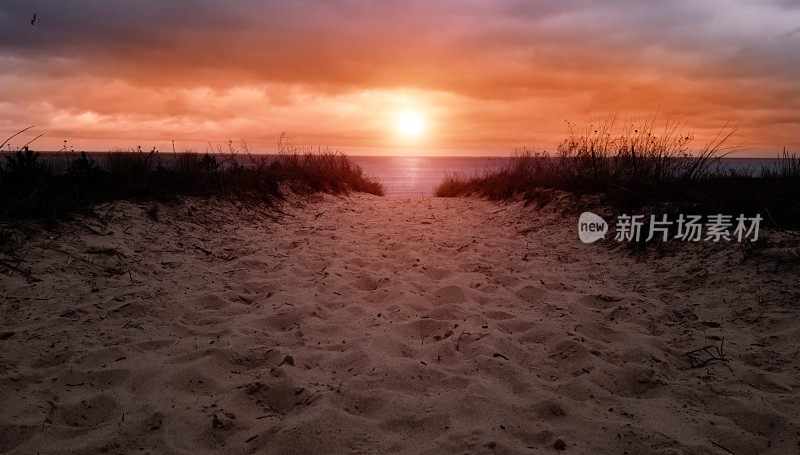 在日落或日出时，从沙丘到海洋，到海滩