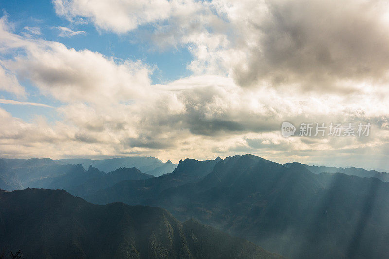 阳光透过云层在山上