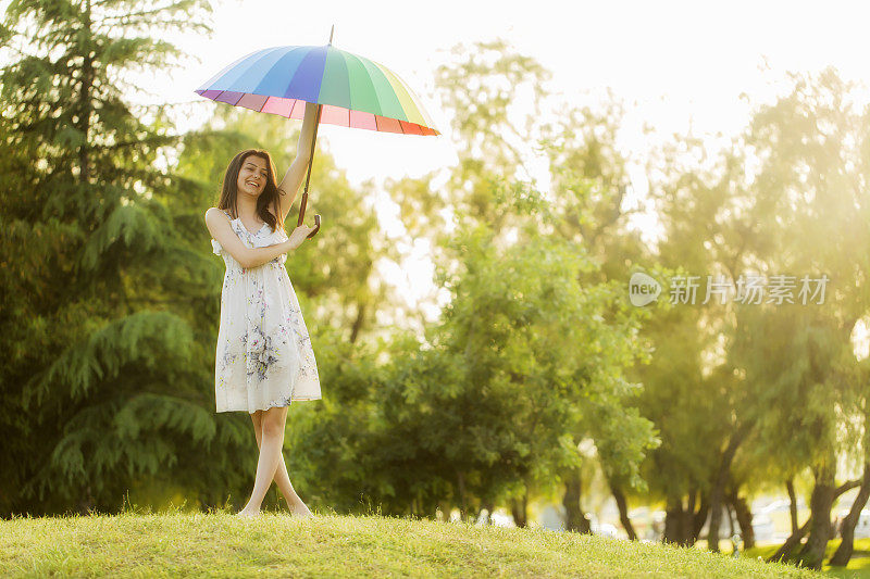 拿着雨伞站在田野里的女人