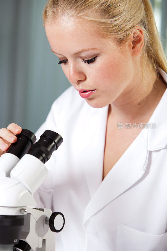 年轻女子在看显微镜