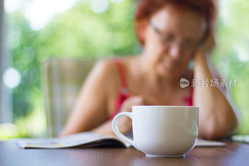 度假的女人看报纸，喝咖啡