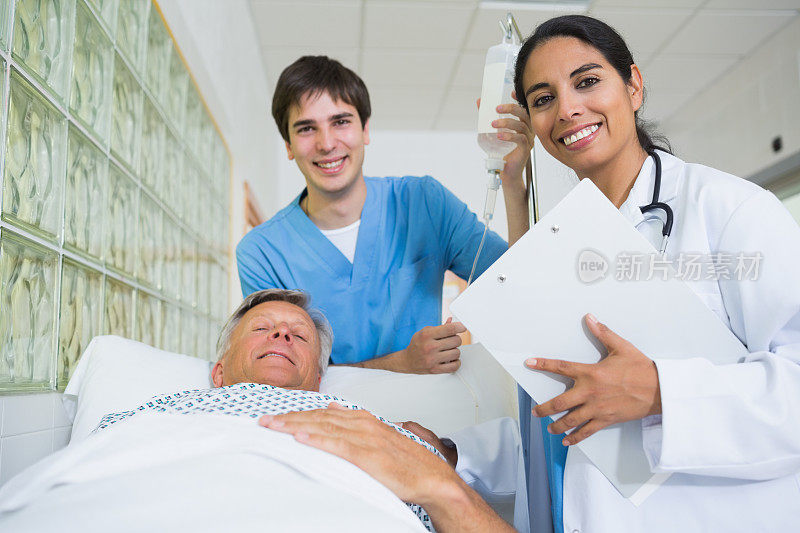 微笑的医生和男护士与一个病人