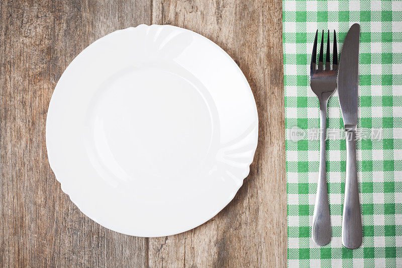 空盘子和桌布，叉子和刀