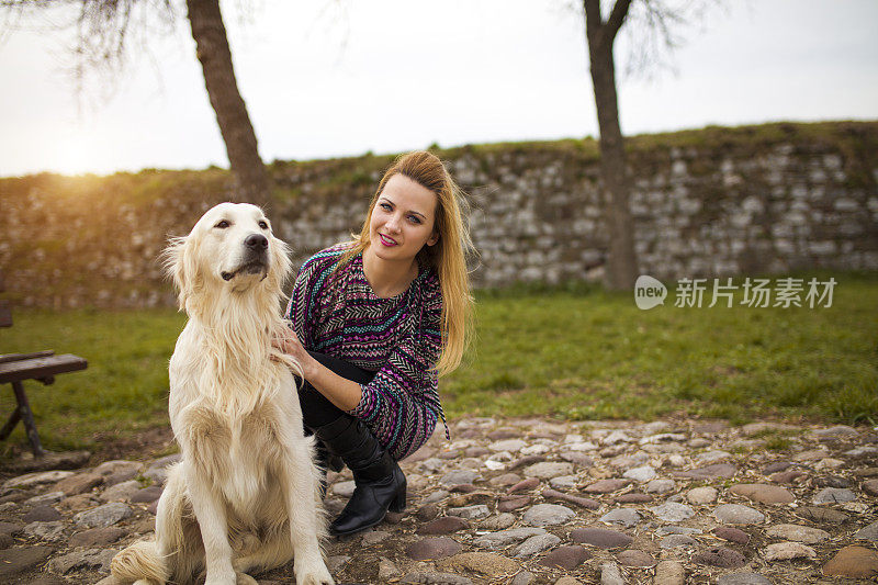 美丽的年轻女子与金毛猎犬