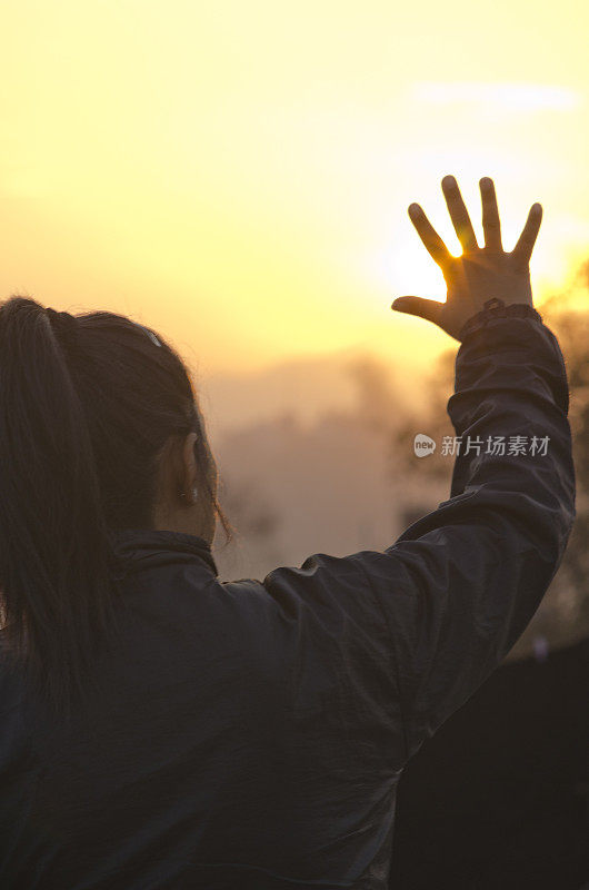 一个女人向太阳展示手掌