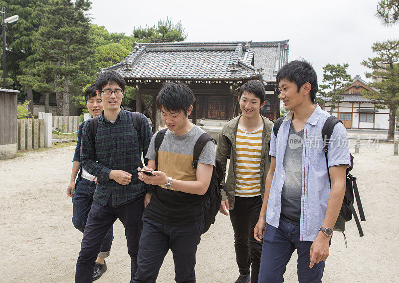 年轻的日本学生参观寺庙与朋友在日本京都